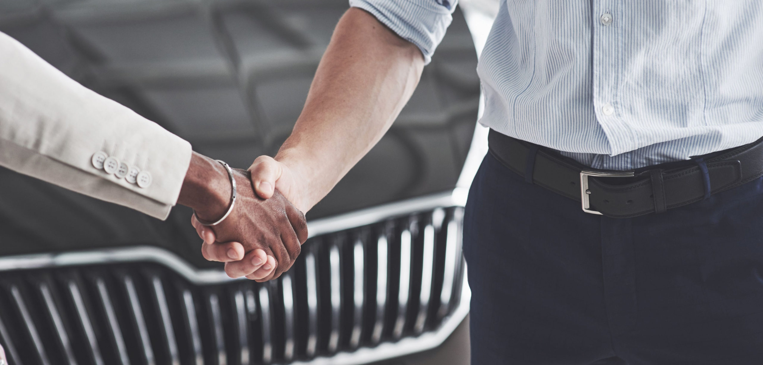 Men Shaking hands in front of a car